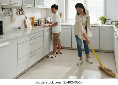 Mother and Son Cleaning Kitchen Together in Morning - Powered by Shutterstock