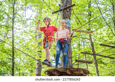 Mother and son climbing in extreme road trolley zipline in forest on carabiner safety link on tree to tree top rope adventure park. Family weekend children kids activities concept - Powered by Shutterstock