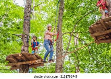 Mother and son climbing in extreme road trolley zipline in forest on carabiner safety link on tree to tree top rope adventure park. Family weekend children kids activities concept Portrait of a - Powered by Shutterstock