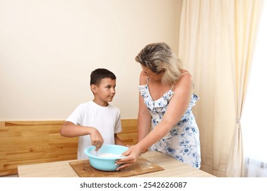 Mother and son cooking pizza at home. - Powered by Shutterstock