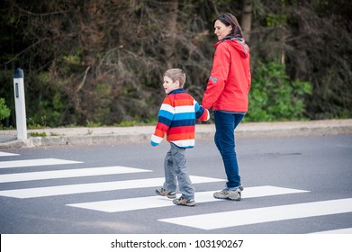 Mother And Son Crossing The Street On The Crosswalk