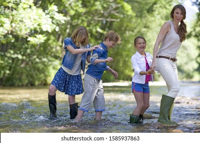 Mother with son and daughters walking in stream, portrait - Powered by Shutterstock