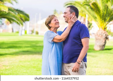 Mother And Son Different Ages Caucasian People Couple At The Park In Green Background Image. Hugging And Feeling Love Between Omther And Son 50 Years Old And 70. Enjoygin Leisure Activity Together