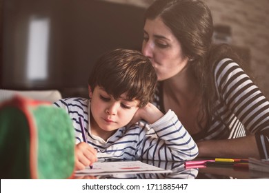 Mother and son doing homework at home, kissing son - Powered by Shutterstock