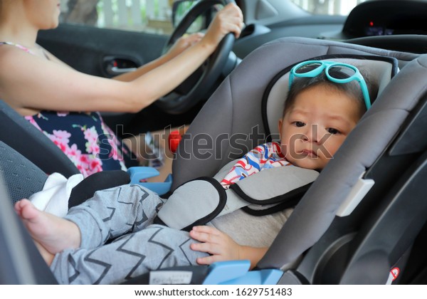 mother and son drive road
trip family travel in summer vacation day, cute baby boy sitting on
car seat