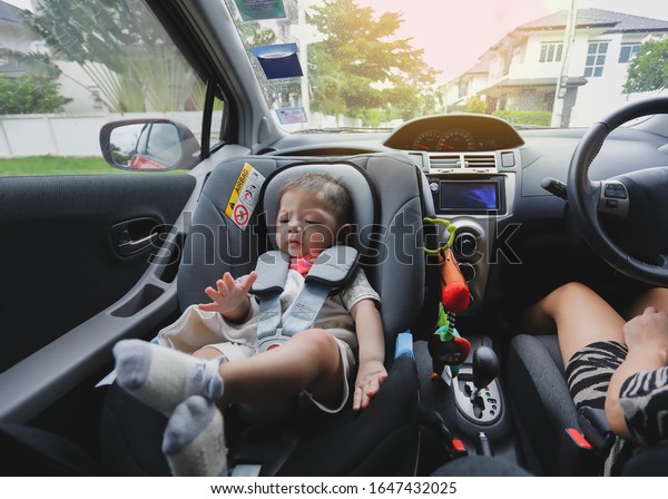 mother and son drive road trip family travel\
in happy vacation day, cute baby boy sitting on car seat safety\
belt lock protection