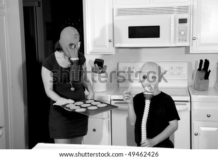 a mother and son enjoy hot fresh baked cookies in their kitchen while wearing gas masks in a post nuclear future in black and white for a edgy futuristic image