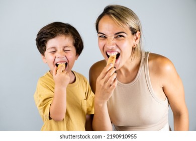 Mother and son enjoying and eating a Latin American snack called tequeños, funny expressions on their faces - Shutterstock ID 2190910955
