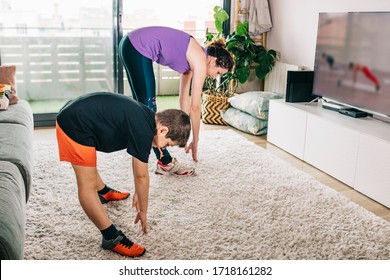 Mother And Son Exercising With A Virtual Class On Tv
