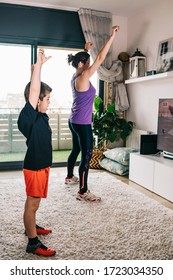 Mother And Son Exercising With A Virtual Class On Tv