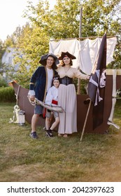 Mother Son Father In Pirate DIY Costume For Halloween. Masquerade Holiday On October 31. Capitan Hook Family. Birthday Party On The Backyard Lawn Outside. Girl Trick-or-treat. Family Look Parenthood