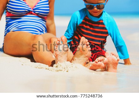 mother and son feet on tropical beach