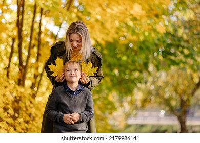 Mother and son have fun together. Family walk in the park in autumn. Hello October. Thanksgiving holiday. Happy motherhood. Childhood. Maple leaves. Fun play together. Leaf ears. Fall - Powered by Shutterstock