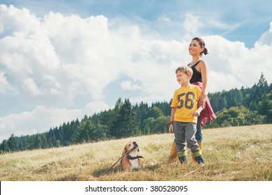 Mother With Son And His Dog Walk On The Golden Field