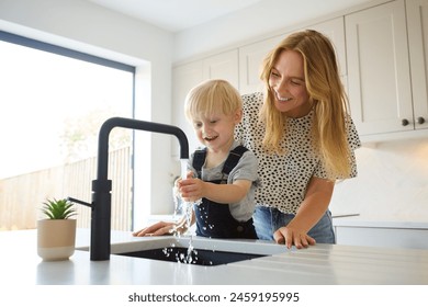 Mother With Son At Home In Kitchen Washing Hands In Sink Or Basin Together - Powered by Shutterstock