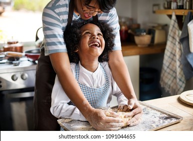 Mother and son kneading dough in the kitchen - Powered by Shutterstock