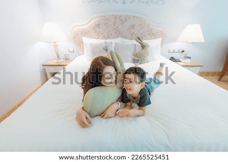 Similar – Relaxed mother and sons playing over the bed