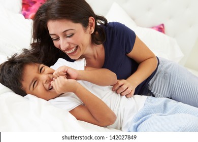 Mother And Son Lying In Bed Together