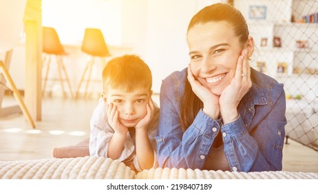 Mother And Son Are Lying Happily Together In The Living Room Side By Side With Their Hands On Their Chins