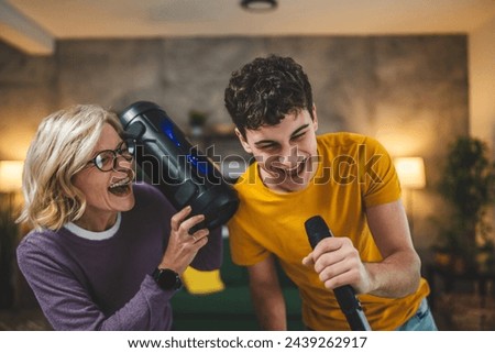 mother and son mature woman teenage man happy smile sing dance at home