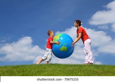 Mother with  son play an inflatable globe in  day-time stand  on  grass - Shutterstock ID 70475155