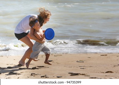 Mother And Son Playing On Beach