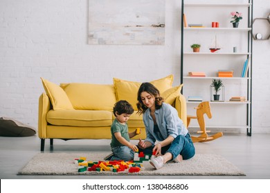 Mother and son playing on carpet in living room - Powered by Shutterstock