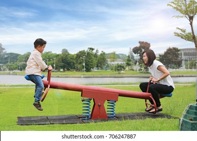 Mother with son playing seesaw in the park. - Powered by Shutterstock