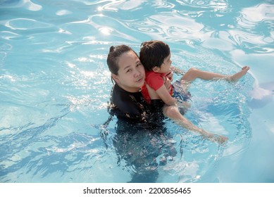 Mother and son playing in swimming pool - Shutterstock ID 2200856465