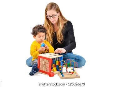 Mother And Son Are Playing Together As Part Of The Creative Children Therapy. A Therapist Is Working With Little Child. Didactic Therapeutic Toys For Autism.  