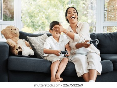 Mother and son playing video games, having fun and enjoying quality time together. Cheerful, bonding and carefree child and parent using a gaming console or interactive modern technology - Powered by Shutterstock