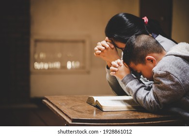 Mother and son praying and praising God at home, sitting on wooden sofa in living room - Powered by Shutterstock