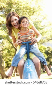 Mother And Son Riding On See Saw In Playground