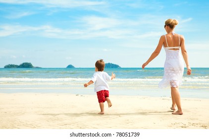 Mother And Son Running On Beach