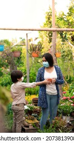 Mother And Son Shopping In A Garden Store. Hispanic Family. Copy Space.