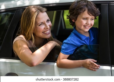 Mother and son sitting in a car while looking outside