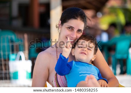Mother and son sitting on the beach