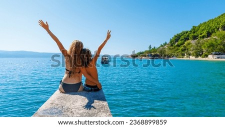 Mother and son sitting on pier enjoying beautiful sea- travel, vacation,tropical holiday destination