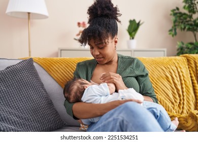 Mother and son sitting on sofa breastfeeding at home - Shutterstock ID 2251534251