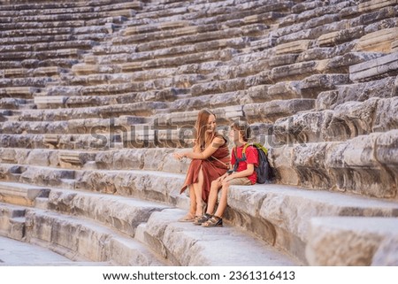 mother and son tourists explores Aspendos Ancient City. Traveling with kids concept. Aspendos acropolis city ruins, cisterns, aqueducts and old temple. Aspendos Antalya Turkey. turkiye