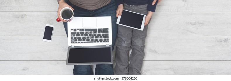 mother and son using internet on tablet pc and laptop