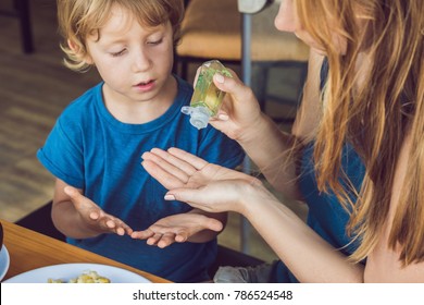 Mother And Son Using Wash Hand Sanitizer Gel In The Cafe.