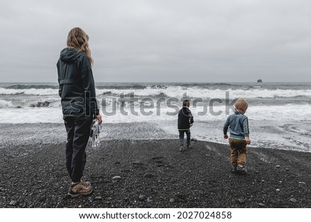 Mother and sons at the water's edge on Rialto Beach in Olympic National Park.