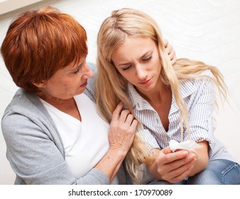 Mother Soothes Crying Daughter. Mature Woman Calm Young Sad Woman 