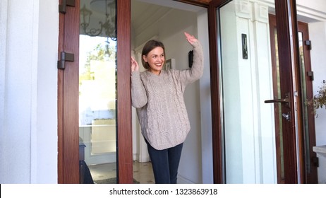 Mother Standing By Door And Waving Hand To Children Walking To School, Goodbye