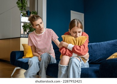 Mother supporting child upset teen girl during difficult adolescence stage, loving parent comforting child at home. Sad teenage daughter crying and feel anxious, being bullied at school - Shutterstock ID 2287952421