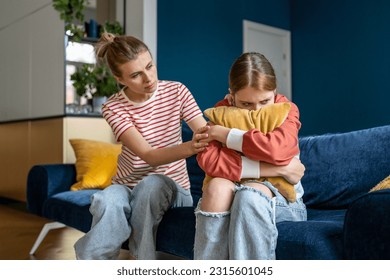 Mother supporting child upset teen girl during difficult adolescence stage, loving parent comforting child at home. Sad teenage daughter crying and feel anxious, being bullied at school - Shutterstock ID 2315601045