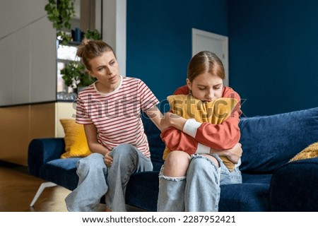 Mother supporting child upset teen girl during difficult adolescence stage, loving parent comforting child at home. Sad teenage daughter crying and feel anxious, being bullied at school