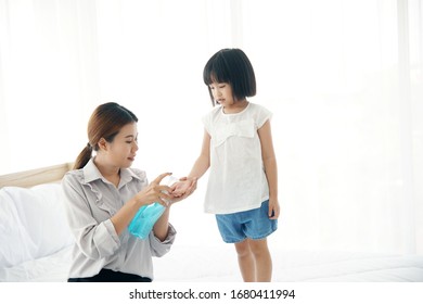 Mother takes care of  her baby by Press the sanitizer gel to wash her daughter's hand to prevent the coronary virus or covid-19                        - Shutterstock ID 1680411994