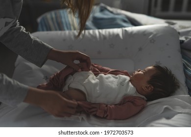 Mother Taking Care Of Her Baby Infant Boy Or Girl While Lying On Bed At Home In Dark Room At Night - Motherhood Concept Real People Caucasian Woman With Her Small Son Or Daughter Changing Clothes